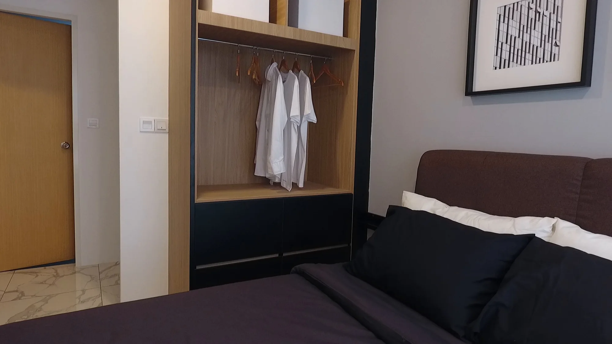 Master bedroom with open wardrobe and dark bedding