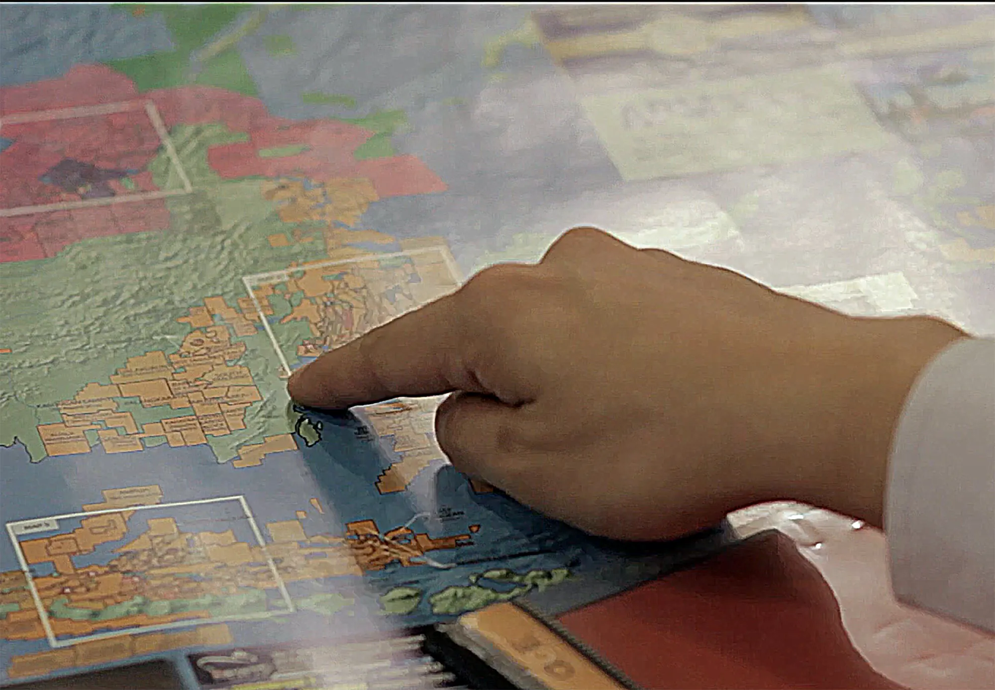Hand pointing to a location on a map