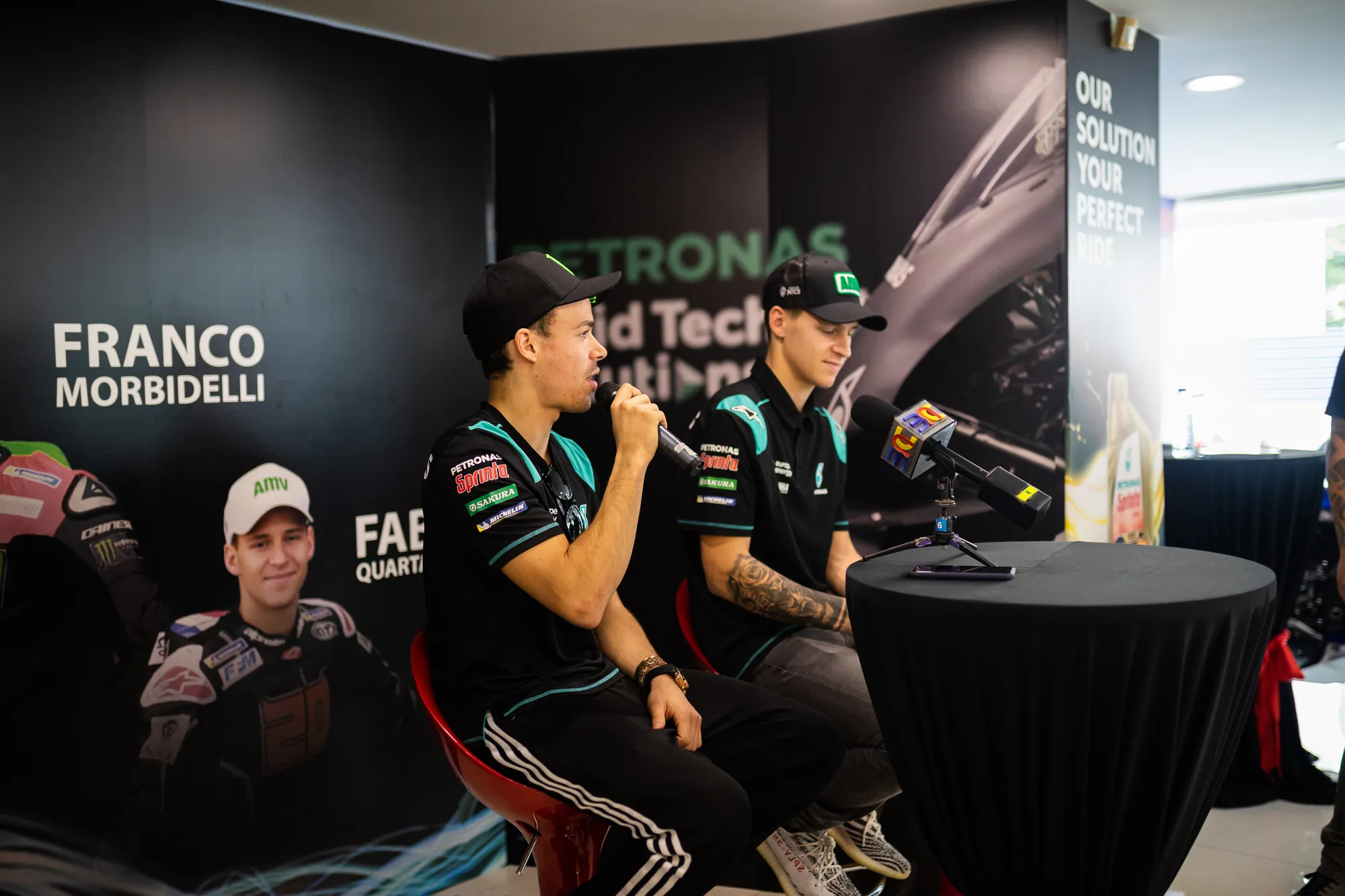 Riders answering questions on microphone at the session